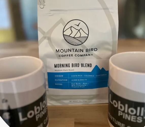 bag of coffee and two coffee cups sitting on a table